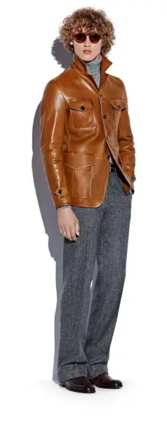 ブラム・ヴァルブラハトは、トム フォードのブラウン レザー ミリタリー ジャケット、タートルネック セーター、グレーのソフト ツイード パンツを着ています