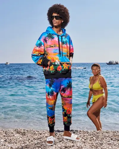 Model Dame Lo bærer en matchende hættetrøje og joggersæt med hvide slides fra Dolce & Gabbana