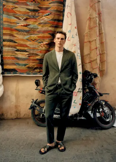 モロッコの街路に繰り出すクエンティン・デミースターは、リネンのテーラードスーツに黒のレザーサンダルを合わせたモデルです。