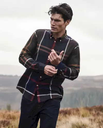 Andando all'aria aperta, Sam Way indossa una camicia a quadri di Barbour