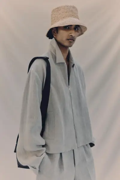 지누 마하데반(Jeenu Mahadevan)은 블루종 재킷과 플리츠 팬츠 등 어울리는 리넨 세트를 입었습니다.