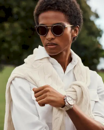 Sprytna wizja Ralpha Laurena. Stan Taylor nosi koszulę i sweter o warkoczowym splocie przerzuconym przez ramiona.