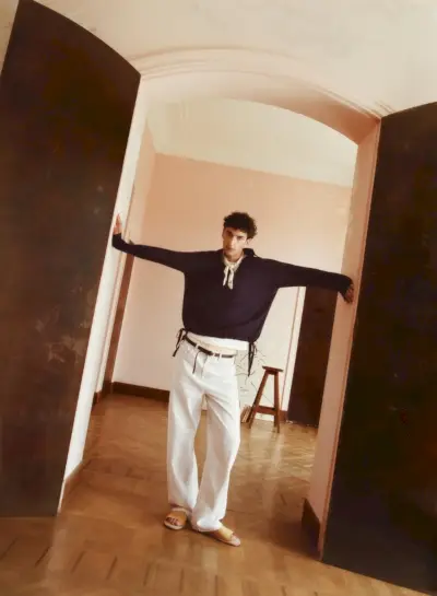 모델 하비브 마소비치(Habib Masovic)는 추상 프린트 반다나, 스키니 벨트, 스트라이프 릴랙스핏 팬츠, 스트랩 스웨이드 샌들이 달린 스트랩 디테일 폴로 셔츠를 착용했습니다.