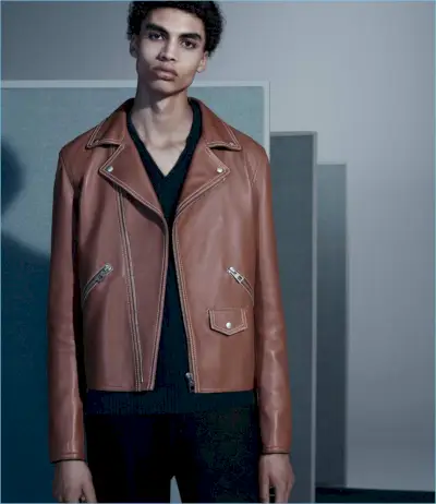 レザーのロエベ ジャケットをクールに着こなすソル ゴスは、イニス マインの V ネック セーターとメゾン マルジェラのパンツも着ています。