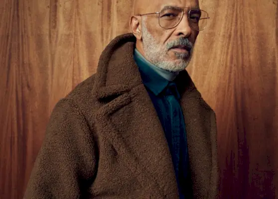 מלפנים ובמרכז, לונו ברזיל עוטה מעיל שרלינג חום עם ז'קט חולצה קטיפה.