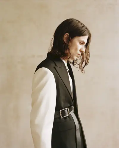 横顔を見せるジェームス・ベイはアレキサンダー・マックイーンを着ています。