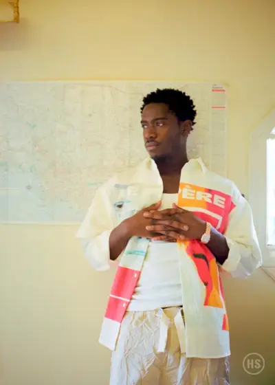 サマーニュートラルを取り入れたダムソン・イドリスは、ル・ペールのシャツにパーム・エンジェルスのパンツを合わせ、カルティエの時計を合わせています。