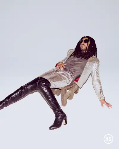 Lenny Kravitz setzt auf einen geschlechterübergreifenden Stil und trägt seine eigene Kleidung, oberschenkelhohe Stiefel und Accessoires.