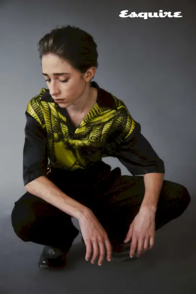 Patekęs į fotostudiją, Raphaelis Luce dėvi Versace išvaizdą su Prada batais.