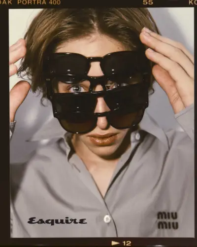 Raphaelis Luce'as dėvi „Miu Miu“ marškinius su Oliverio Peoples akiniais nuo saulės.