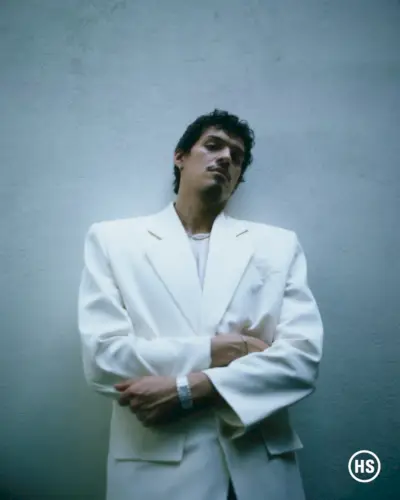 Omar Apollo bär en skir Dries Van Noten-topp med en Saint Laurent-kavaj och Uniform Object-örhängen.