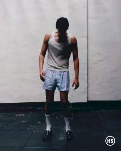 Omar Apollo omfamnar en rå look och står dränkt, klädd i en enkel Prada-ensemble.