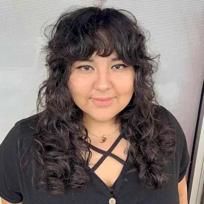 Mid-Length Messy Shag for Curly Hair with Bangs for Round Faces