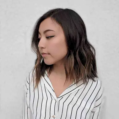Asymmetrical Wavy Layered Medium-Length Haircut for Round Faces