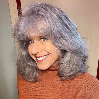 Mid-Length Silver Hair with Thick Layers and Light Bangs for Older Women