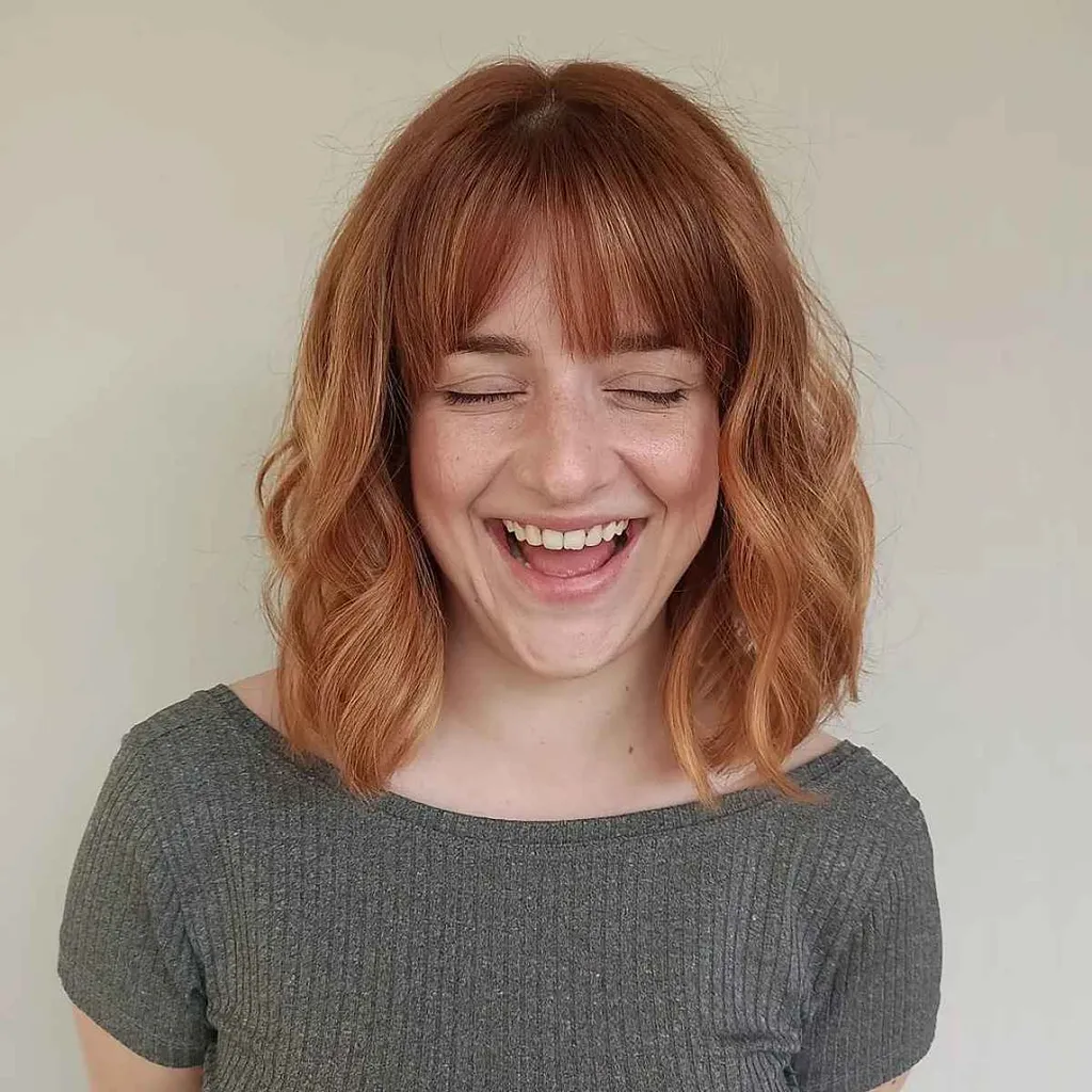 Capelli medi ondulati con frangia dritta' title=