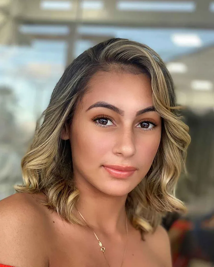 Capelli spazzati lateralmente con riccioli' title=