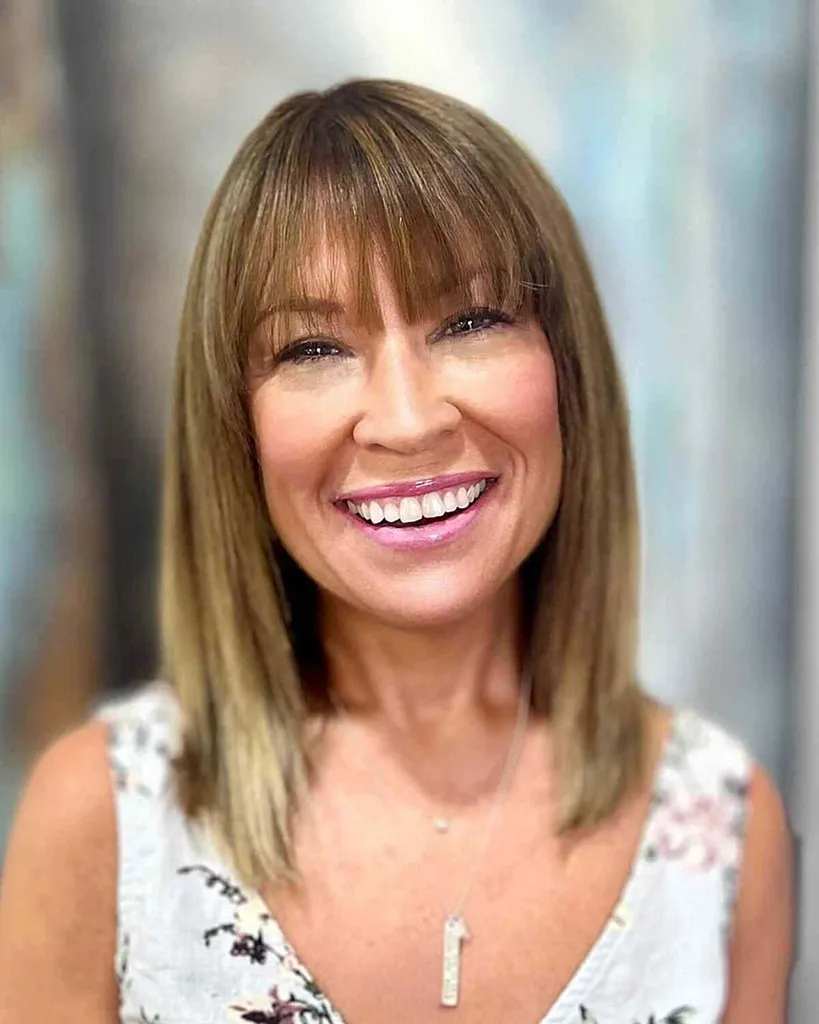 Capelli castani chiari lunghi fino alla clavicola con frangia a cascata' title=