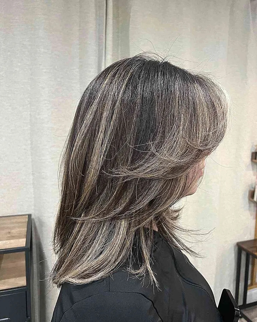 Cabelo preto com penas de comprimento médio com mechas loiras' title=