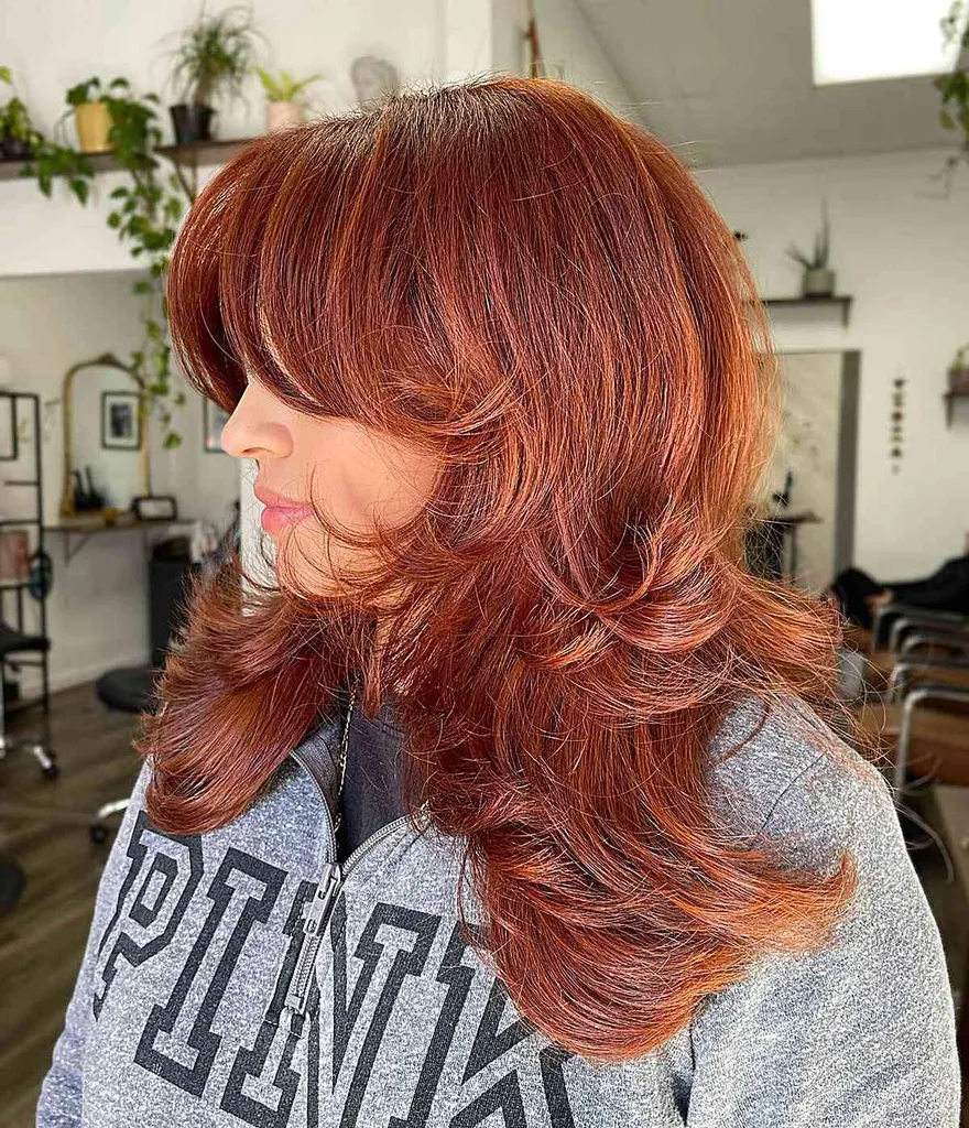 Corte volumoso de penas médias com franja na altura da maçã do rosto' title=