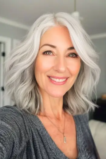 Mittellange Frisur mit silbernen Wellen.