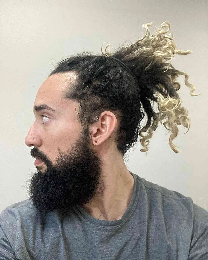 Rastas de forma libre en una cola de caballo para hombres con cabello negro y puntas rubias' title=