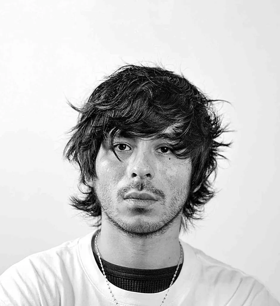 Corte de pelo alado moderno con flequillo hasta los ojos para hombres' title=