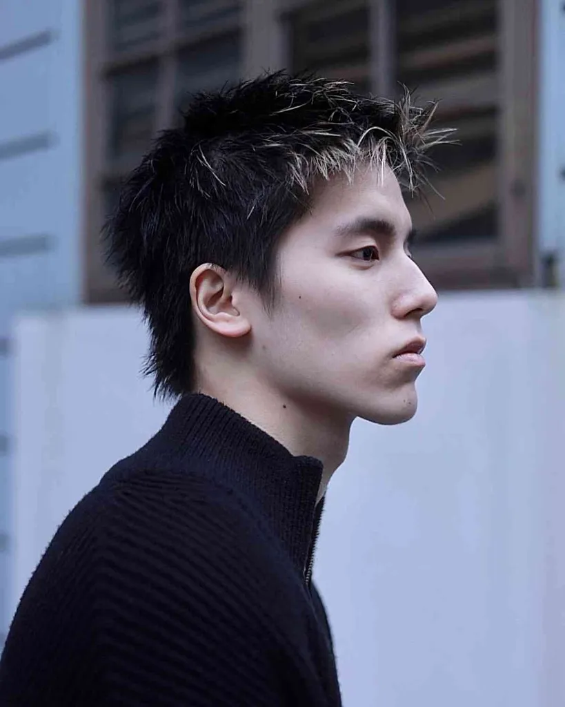 Jaunų vyrų slenkantys plaukai su priekiniais apšerkšnijusiais blondiniais antgaliais' title=