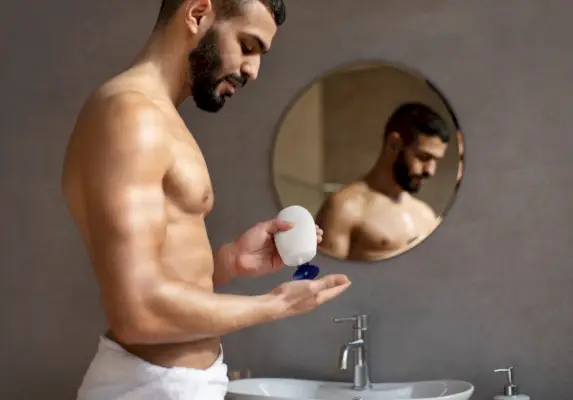 Homme mettant de la lotion
