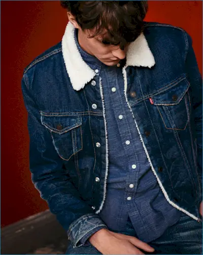 Modelul Matthew Hitt poartă o jachetă trucker din denim sherpa de la Levi