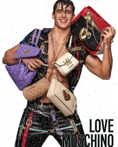 Pietro Boselli je ves nasmejan, ko pozira s torbami za Love Moschino