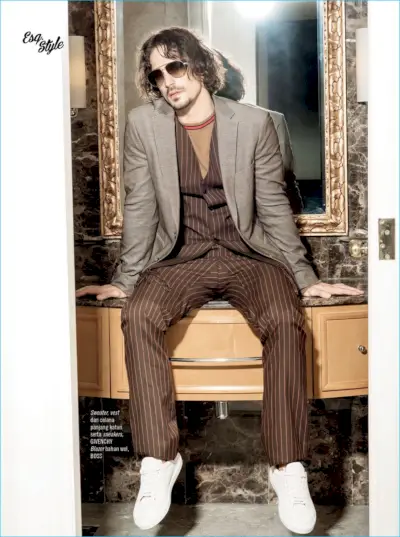 Wong Sim fotografa Gustavo Krier con un blazer BOSS Hugo Boss con maglione, gilet, pantaloni e scarpe da ginnastica di Givenchy.