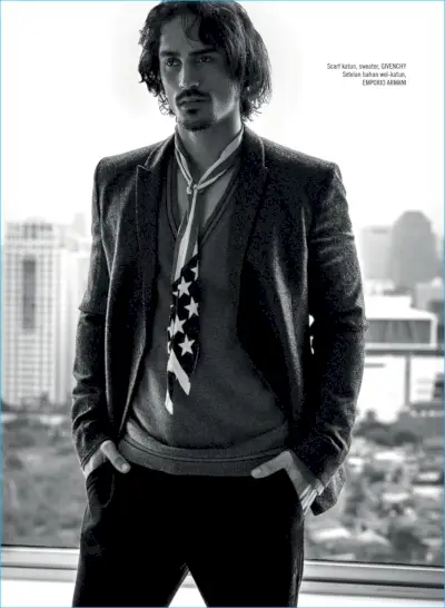 Il modello Gustavo Krier sfoggia una sciarpa Givenchy e un maglione con scollo a V con un abito Emporio Armani.