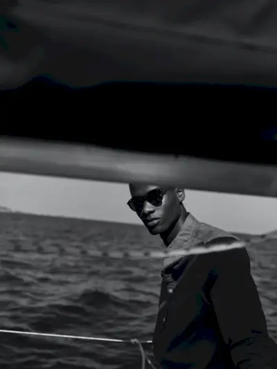 Rachide Embalo sprejema sezonski stil v ozki barvani srajci iz 100 % lanu znamke Massimo Dutti.