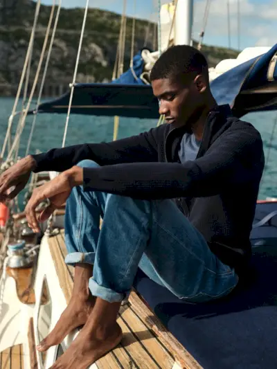 Uživa v mirnem trenutku, Rachide Embalo oblikuje jopico iz kašmirja z laneno majico in kavbojkami Massimo Dutti.