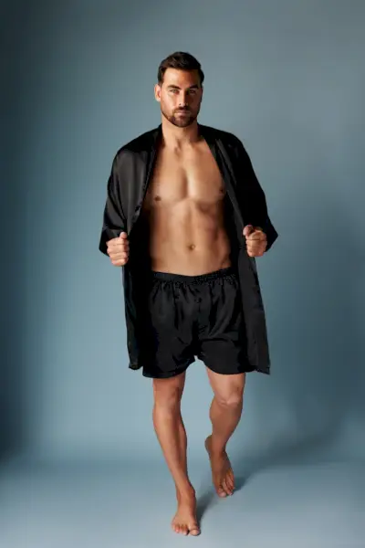 Al frente y al centro, Marc Jacobs luce una bata de satén a juego y boxers en negro de Frederick.