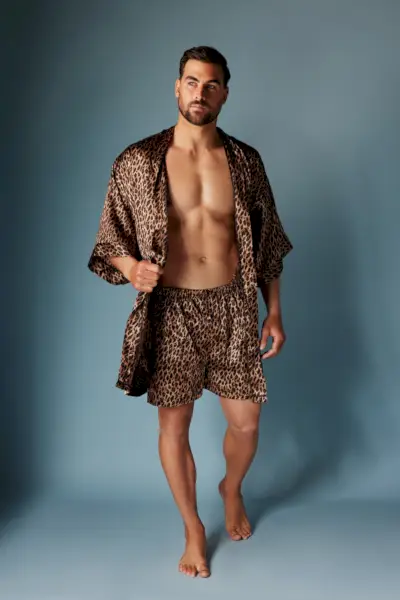 Haciendo una declaración audaz, Marc Jacobs modela una bata de satén de leopardo y unos boxers de Frederick a juego.