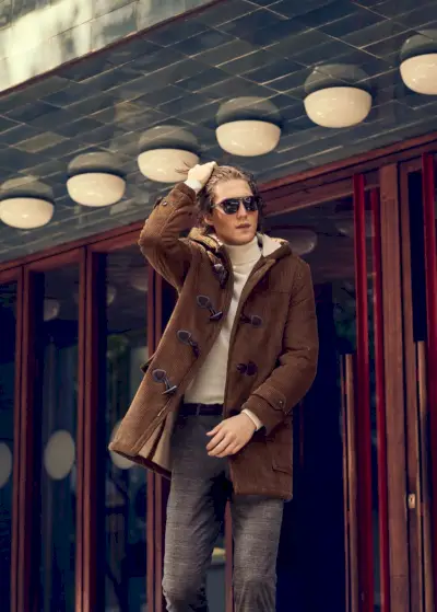 クールなビジョンを持ったボイド ゲイツは、Mango のブラウン コーデュロイ ダッフルコートを着こなしています。