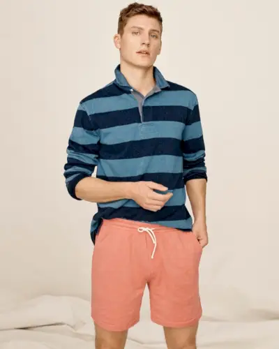 Apresentando um estilo icônico, Mikkel Jensen modela uma camisa de rugby listrada J.Crew 1984 com shorts leves de terry francês desbotados pelo sol.