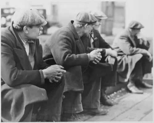 Des hommes au chômage portent des casquettes plates et des manteaux épais sur les quais de New York en 1934.