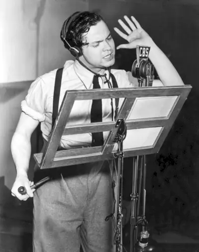 Orson Welles enfile des bretelles et une cravate avec une chemise et un pantalon plissé lors d'une apparition au studio CBS en 1939 pour diriger The Mercury Theatre on the Air.