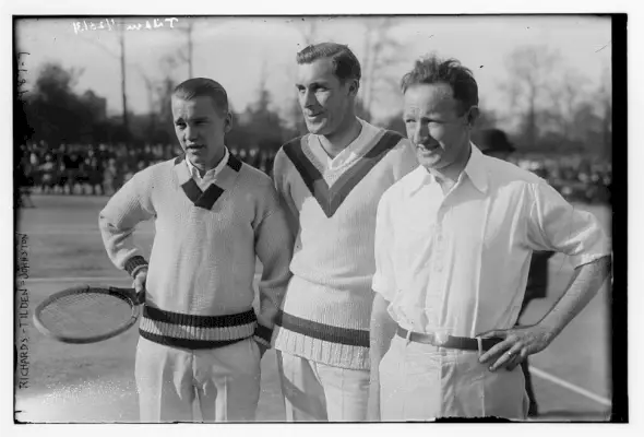 Tenisiści Vincent Richards, Bill Tilden i Bill Johnston pozują do zdjęć podczas meczu tenisowego w 1923 roku w swetrach z dekoltem w kształcie litery V i zwykłych białych koszulach.