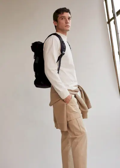 Alexis Petit modelliert einen lässigen Look von Mango, der einen Langarmpullover und eine Cargohose umfasst.