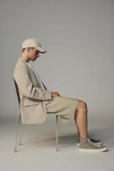 Une vision moderne et élégante, Andreas modèle un short surdimensionné plissé avec un blazer et une casquette Zara.
