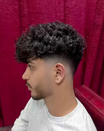 Faded Curly Haircut with Textured Bangs on Gents with Thick Hair