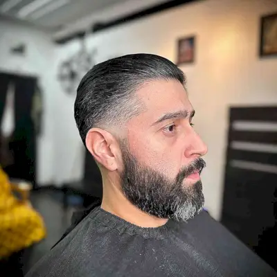 Slicked Back Straight Hair with Low Fade for Mature Men with Beard