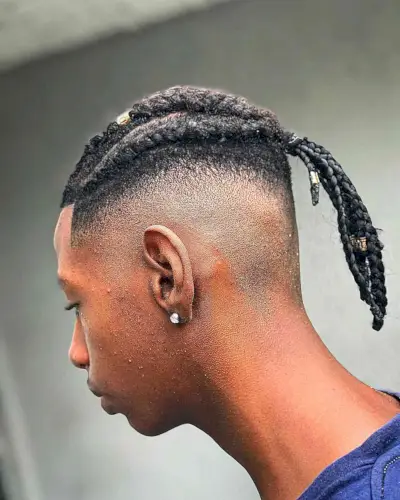 A picture of a black men with a unique cornrow braided bun hairstyle