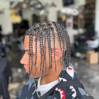 A picture of a black men with medium length dreads and a disconnected undercut