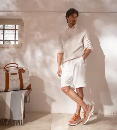 Tenues de couleurs neutres pour hommes : Brunello Cucinelli maîtrise les tons terreux avec un look printemps-été, fini avec ses baskets en tricot chiné de coton orange.