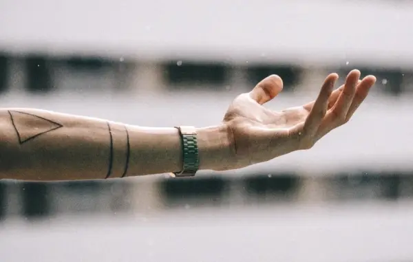 Simple linjer skaber et slående abstrakt design på underarmen, der afspejler en minimalistisk tilgang til kropskunst.